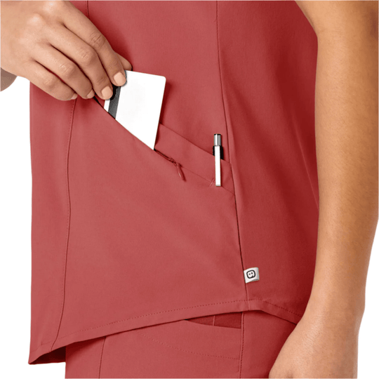 Red scrub top with angled front pocket holding a card and pen