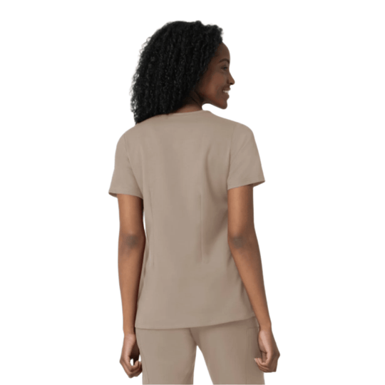 Back view of a woman wearing a beige short-sleeve scrub top and matching pants