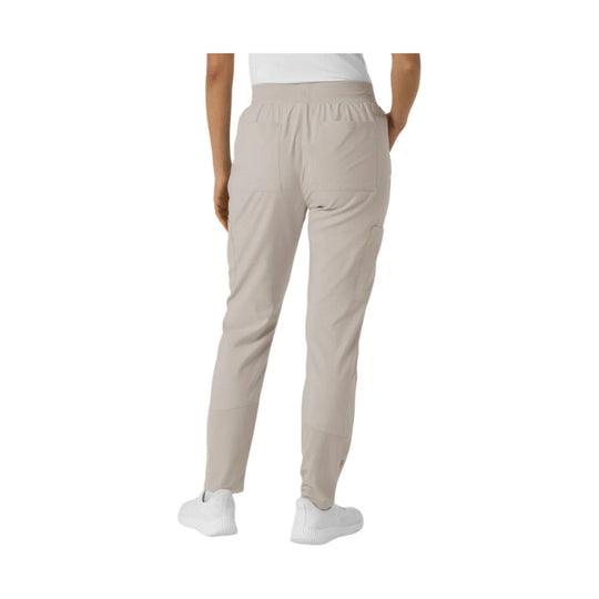 Light beige women's scrub pants shown from the back with patch pockets and tapered legs