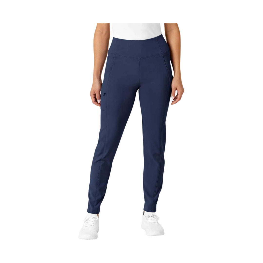 Navy high-waist women’s scrub pants with tapered legs and side pockets, shown on a model with white shoes