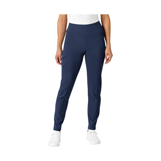 Navy high-waist women’s scrub pants with tapered legs and side pockets, shown on a model with white shoes