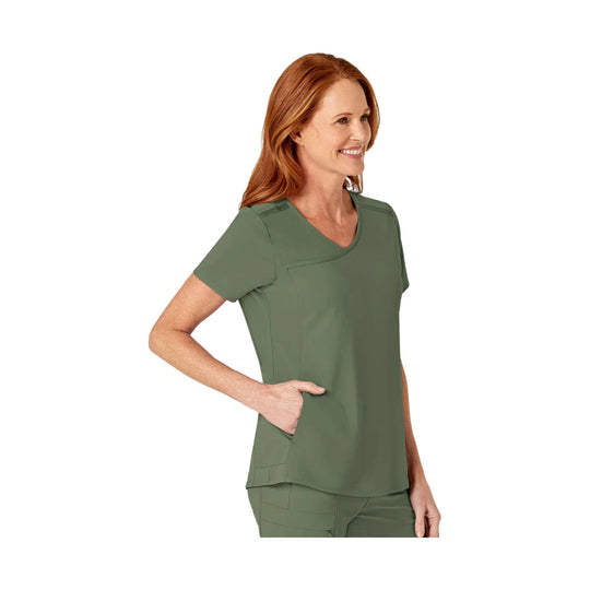 Olive V-neck scrub top with short sleeves and seam details, shown on a model