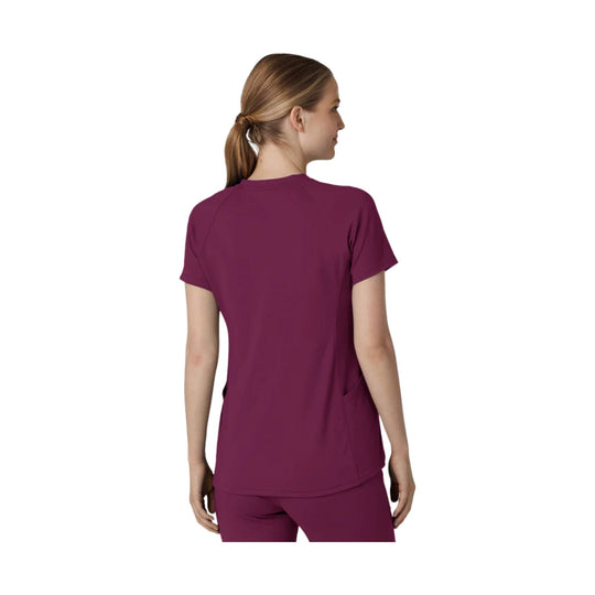 Back view of a short-sleeve burgundy scrub top with raglan seams and a curved hem.