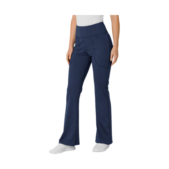 Navy flared yoga scrub pants with a wide waistband and side pockets, shown on a model
