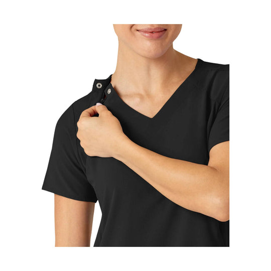 Black V-neck scrub top with shoulder snap closure and short sleeves, shown on a model