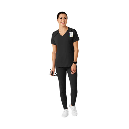 Black short-sleeve V-neck scrub top with matching pants and white sneakers