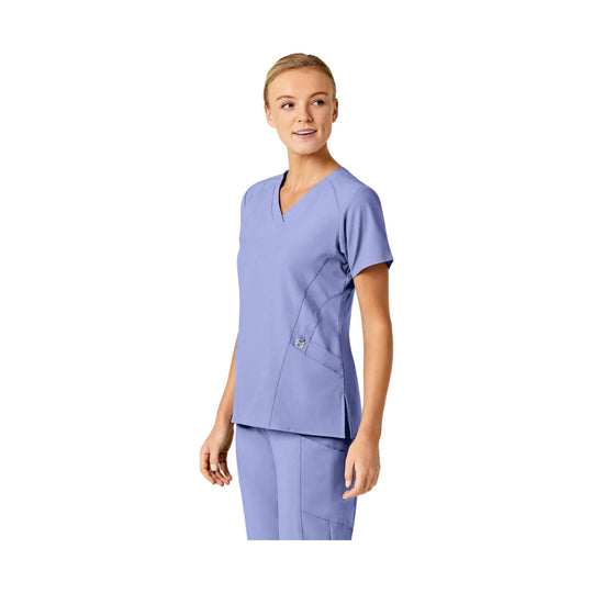 Lavender V-neck scrub top with short sleeves and matching scrub pants, shown on a model