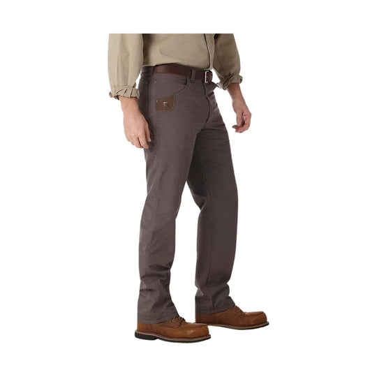 Person wearing brown pants and a beige shirt on a white background