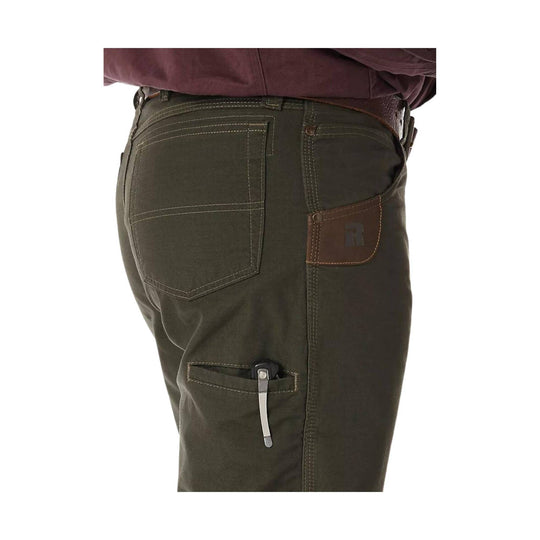 Close-up of green pants with a brown patch on a white background