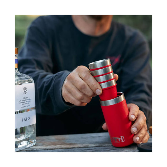 Red stainless steel shot glass stack with case beside a LALO tequila bottle