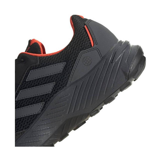 Black athletic shoe with red trim, mesh upper, and a thick textured sole, shown in side view