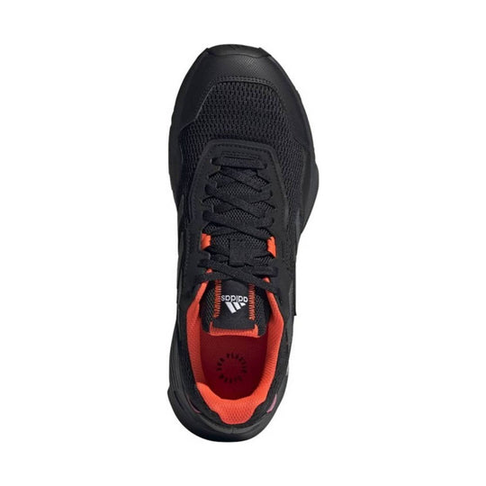 Black athletic sneaker with orange lining, black laces, and a visible adidas logo on the tongue