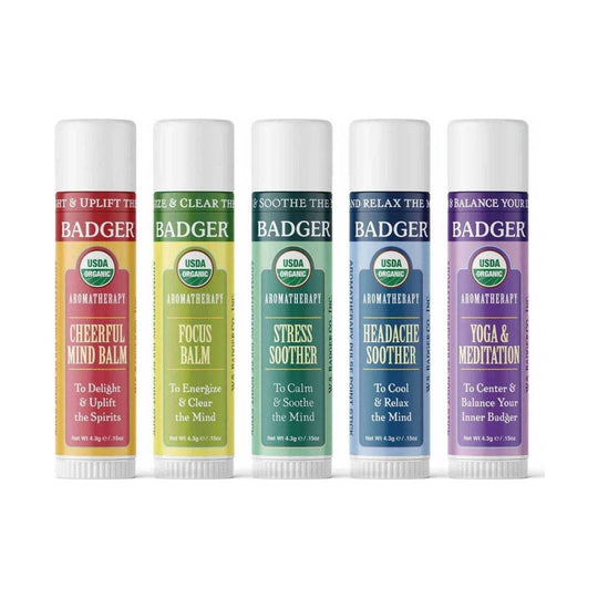 Five colorful aromatherapy balm sticks labeled Cheerful Mind, Focus, Stress Soother, Headache Soother, and Yoga & Meditation