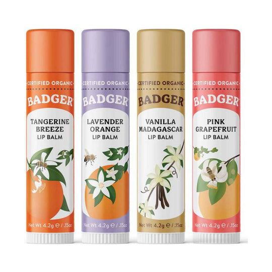 Four lip balm tubes in orange, lavender, gold, and pink with citrus, vanilla, and floral illustrations