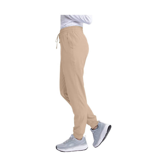 Beige jogger scrub pants with elastic waistband and tapered cuffs, shown with gray sneakers
