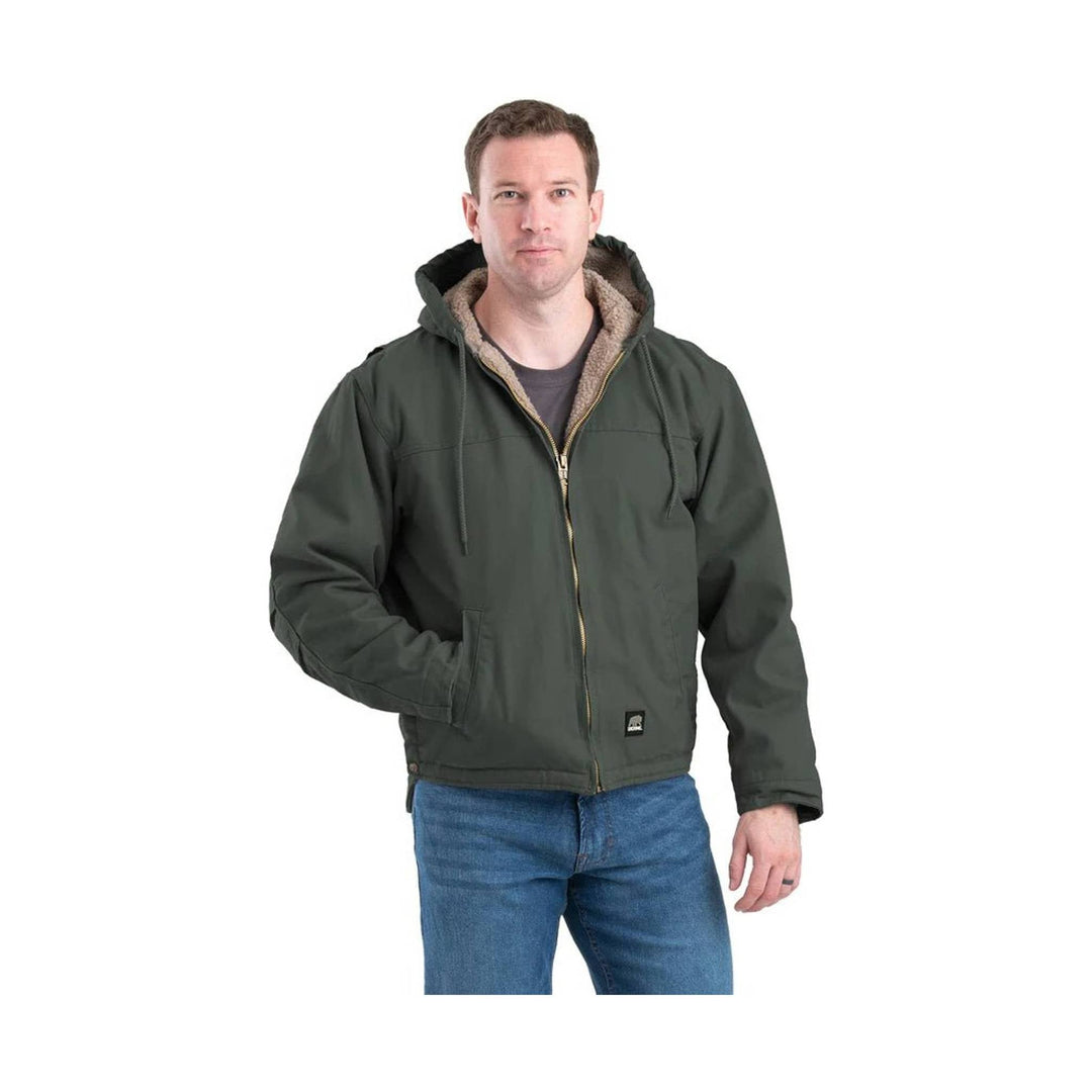 Dark green hooded zip-up work jacket with tan fleece lining, shown front view on a model