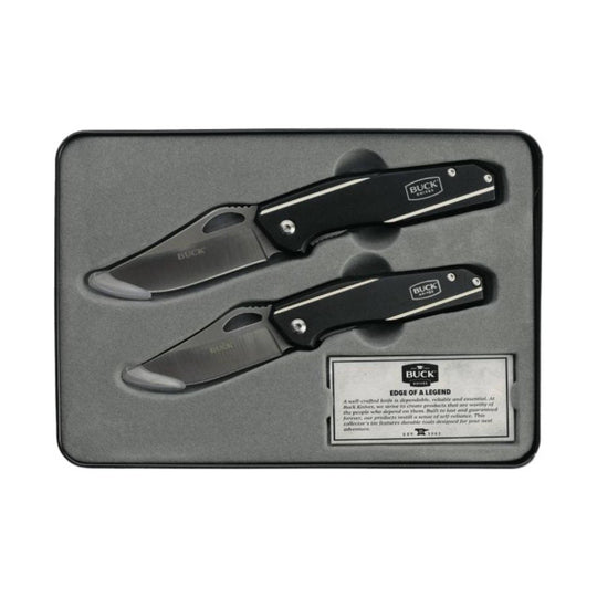 Two black folding knives in a molded display tin with visible Buck Knives branding
