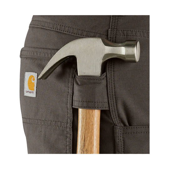 Brown work pant pocket with a hammer tucked into a side loop and a Carhartt tag