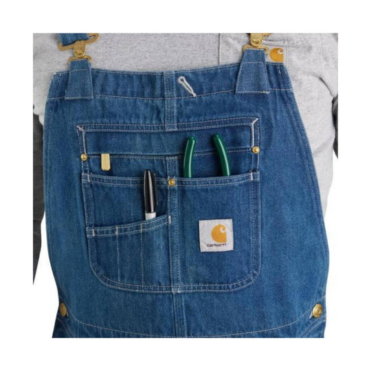 Blue denim bib overalls with multiple front pockets and brass hardware