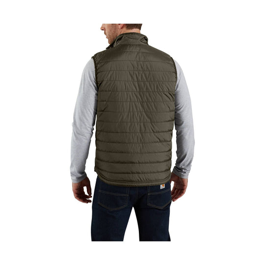 Back view of an olive quilted insulated vest worn over a light gray long-sleeve shirt