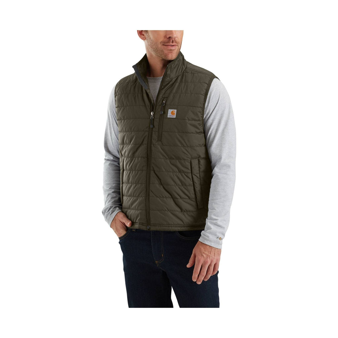 Olive quilted zip-front insulated vest worn over a gray long-sleeve shirt