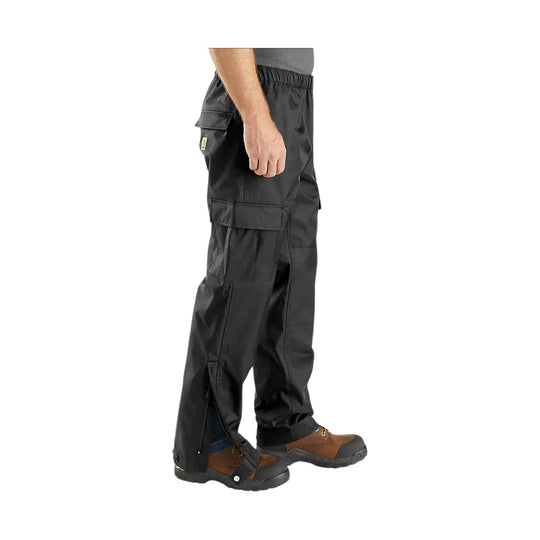 Black rain pants with cargo pockets and side leg zippers, shown on a model with hiking boots