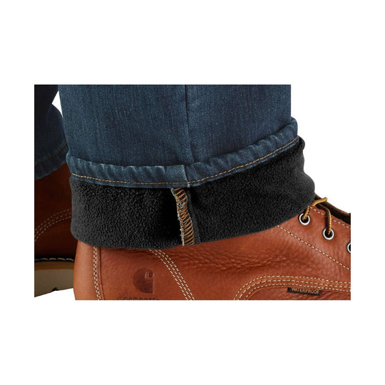 Cuffed dark denim pants with black fleece lining above brown leather work boots
