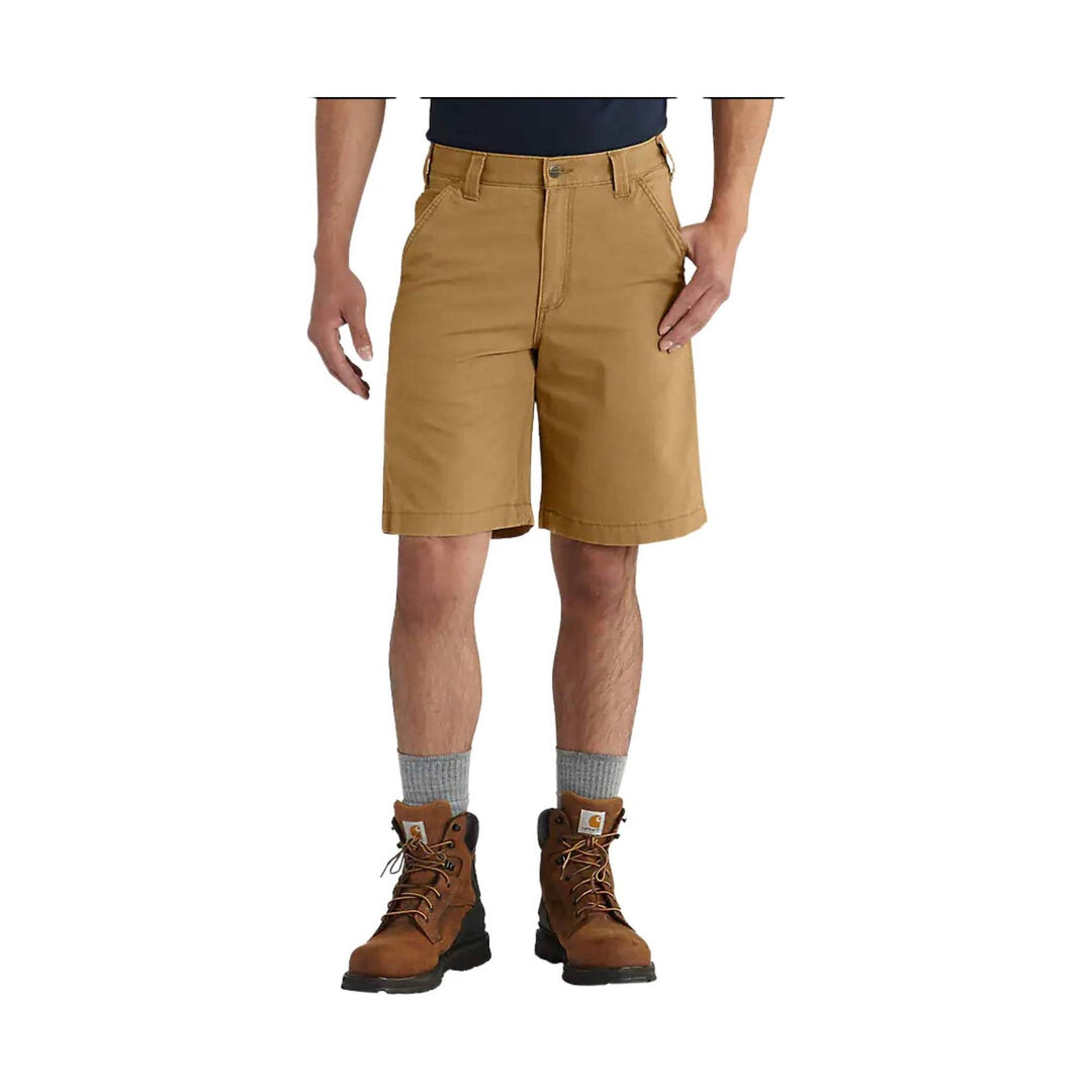 Tan knee-length work shorts worn with boots and socks on a model against a white background