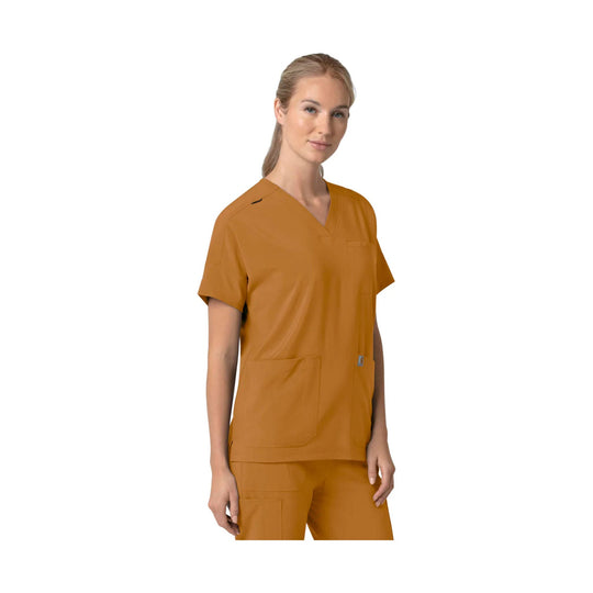 Woman wearing a burnt orange V-neck scrub top with short sleeves and front pockets