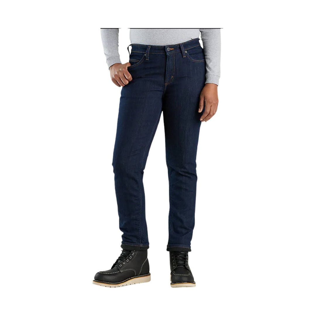 Dark wash slim straight jeans with a relaxed fit, shown with a light gray top and black work boots