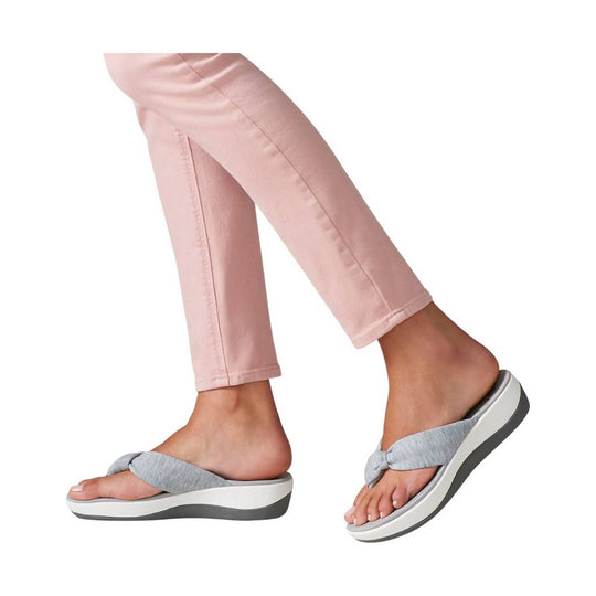Gray slide sandal with twisted strap and white platform sole on a model wearing pink pants