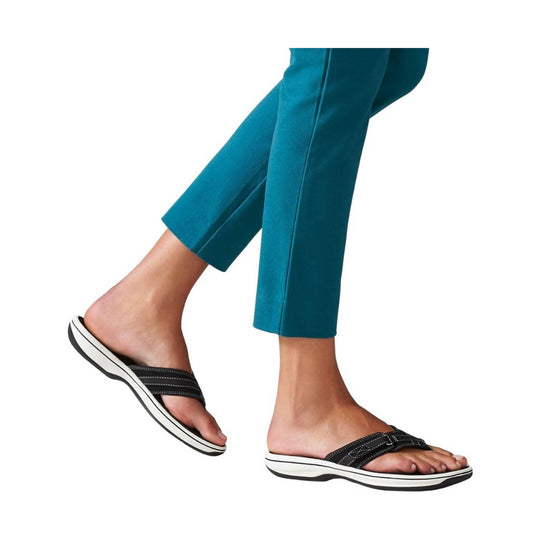 Black slip-on sandals with white platform soles worn with teal cropped pants