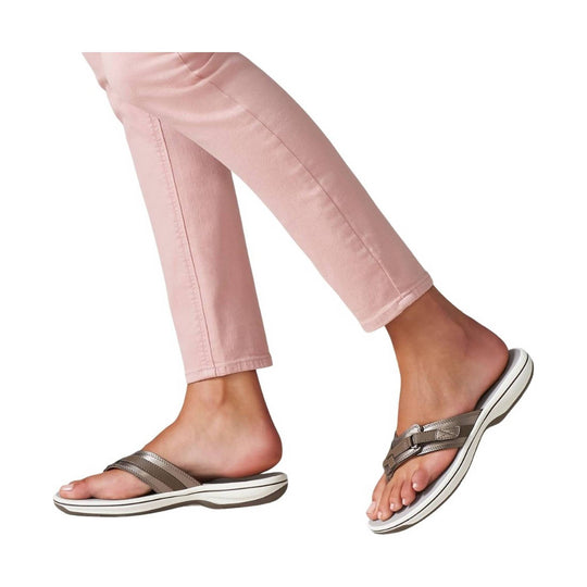Pink cropped pants with taupe-and-white slide sandals