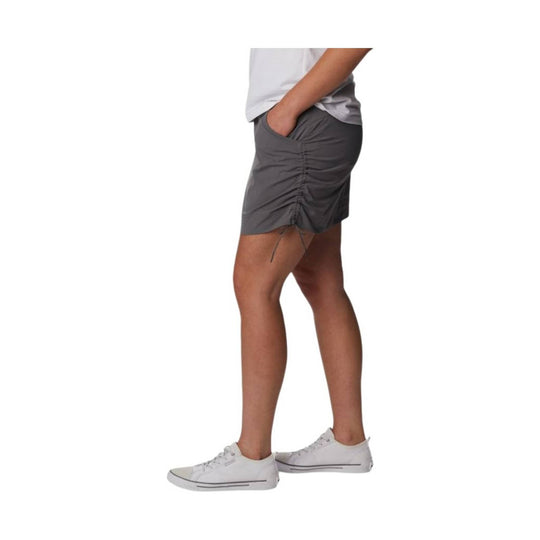 Gray athletic skort with ruched side detail, shown on a model with white sneakers