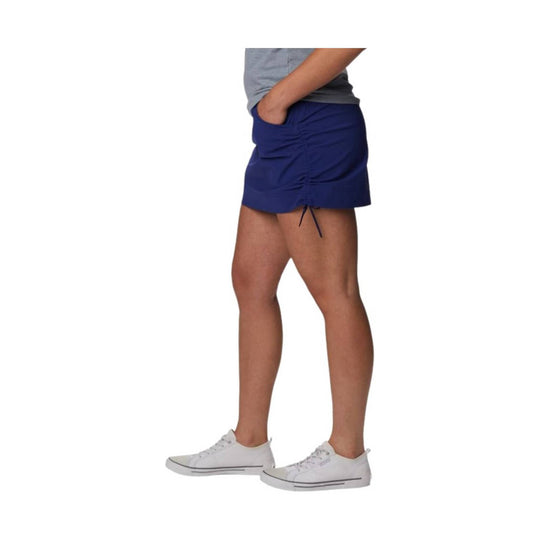 Blue athletic skort with ruched side detail, worn with a gray T-shirt and white sneakers
