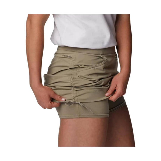 Tan athletic skort with ruched side seams, drawstring hem, and visible Columbia logo