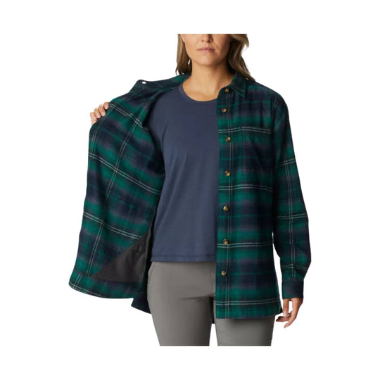 Green and navy plaid button-up flannel shirt worn open over a navy top