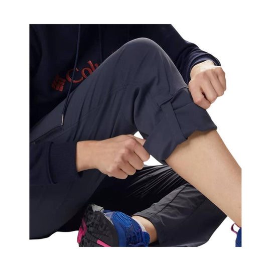 Navy hiking pants with a rolled cuff and cargo pocket, shown on a seated model