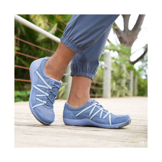 Blue lace-up athletic sneakers worn with cropped pants