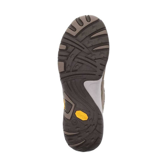 Dark rubber shoe outsole with curved tread patterns and a yellow Vibram insert