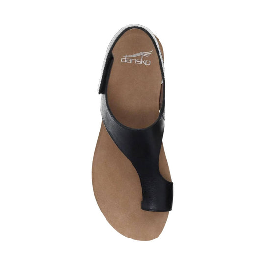 Black leather sandal with a tan footbed and open toe, viewed from above