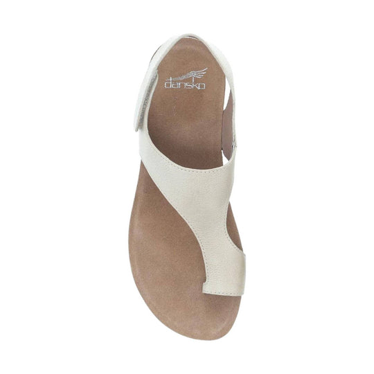 White leather sandal with a brown footbed and visible Dansko logo