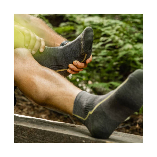 Dark gray ankle hiking socks with yellow trim, shown on a person's feet outdoors
