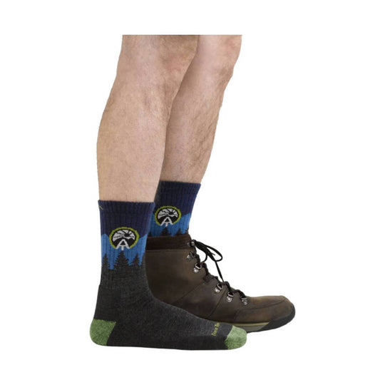 Mid-calf hiking socks with a blue mountain-and-tree pattern worn with brown hiking boots