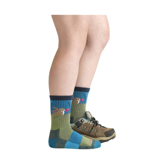 Child wearing blue and olive socks with rabbit-and-bubble pattern, shown with hiking shoes