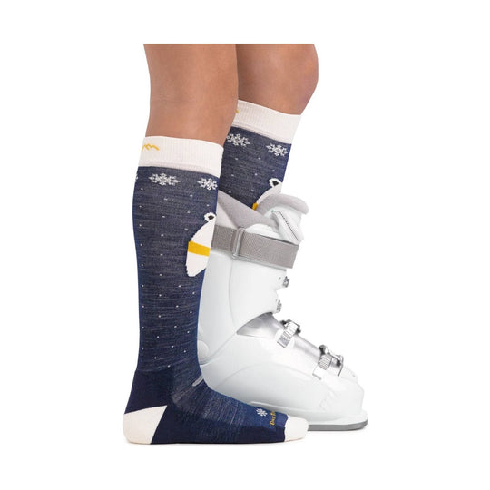 Navy knee-high socks with snowflake and bear pattern worn with white ski boots