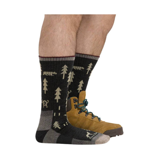 Black midweight hiking socks with tan tree and bear pattern, worn with tan hiking boots
