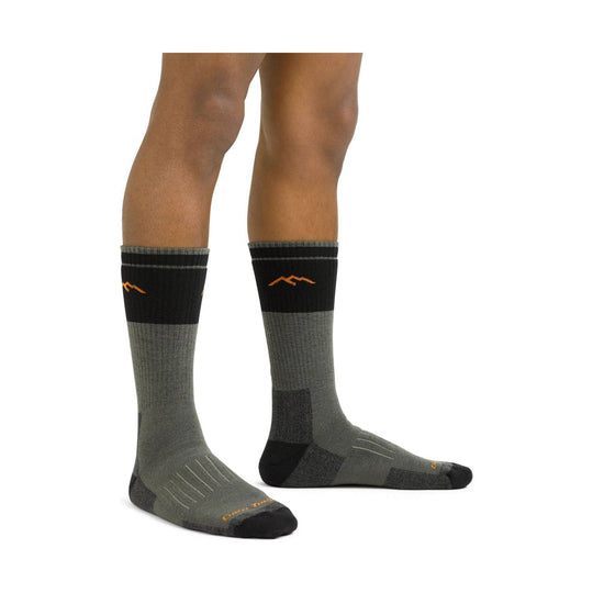 Pair of knee-high wool hiking socks in black and gray with orange accents, shown on model legs