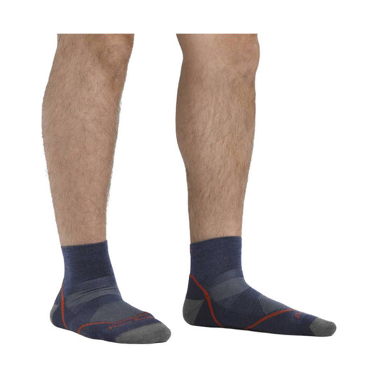 Pair of navy ankle socks with gray toes and heels and orange seam accents, worn on a model.