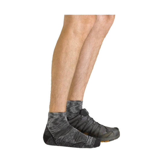 Gray low-cut running socks worn with dark trail shoes on a model’s legs